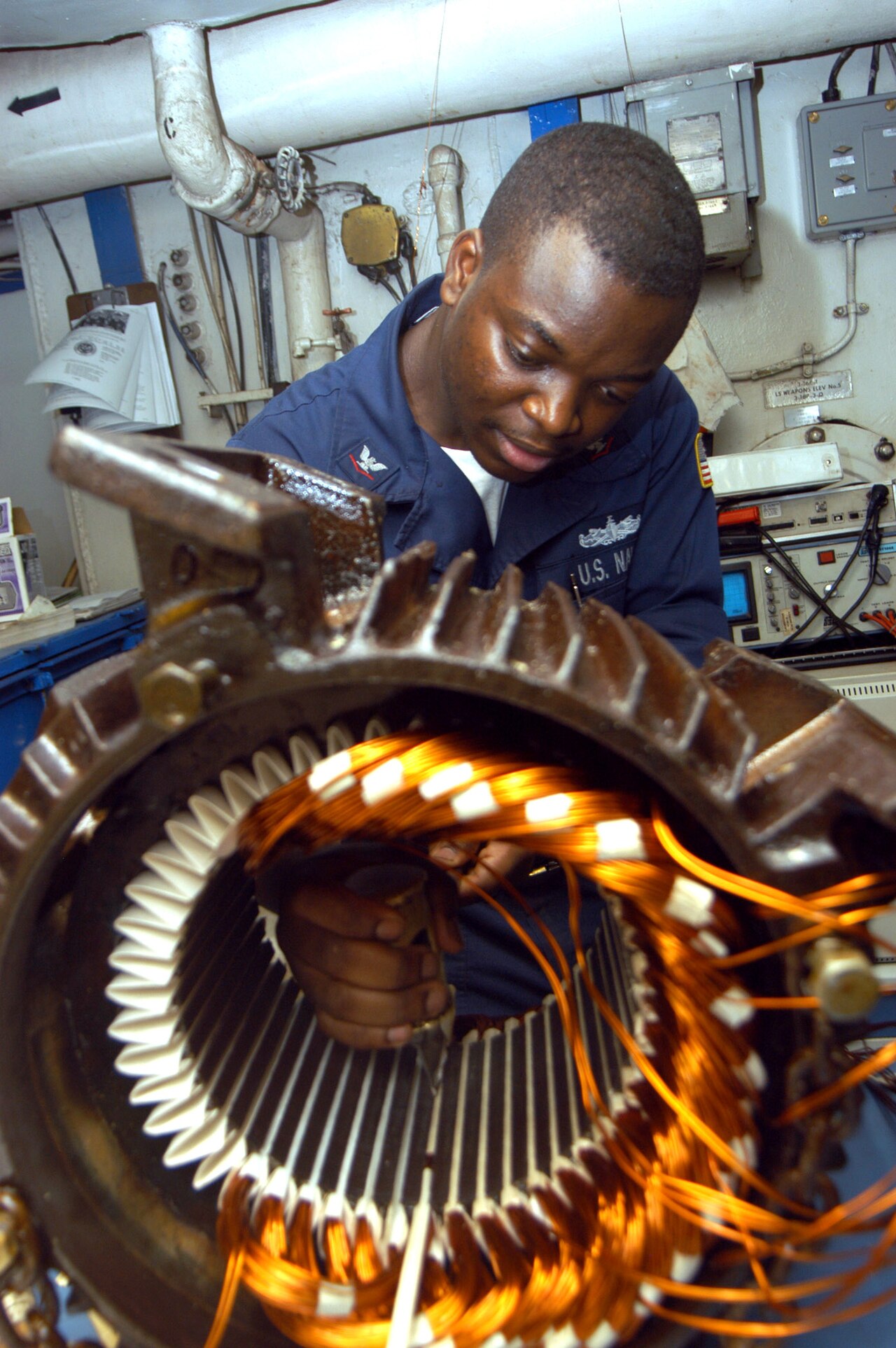 Arabian Gulf (Sept. 2, 2004) - Electrician's Mate 3rd Class Tayo Gbadebo from Lagos, Nigeria, rewires the motor from an Aqueous Film Forming Foam (AFFF)…